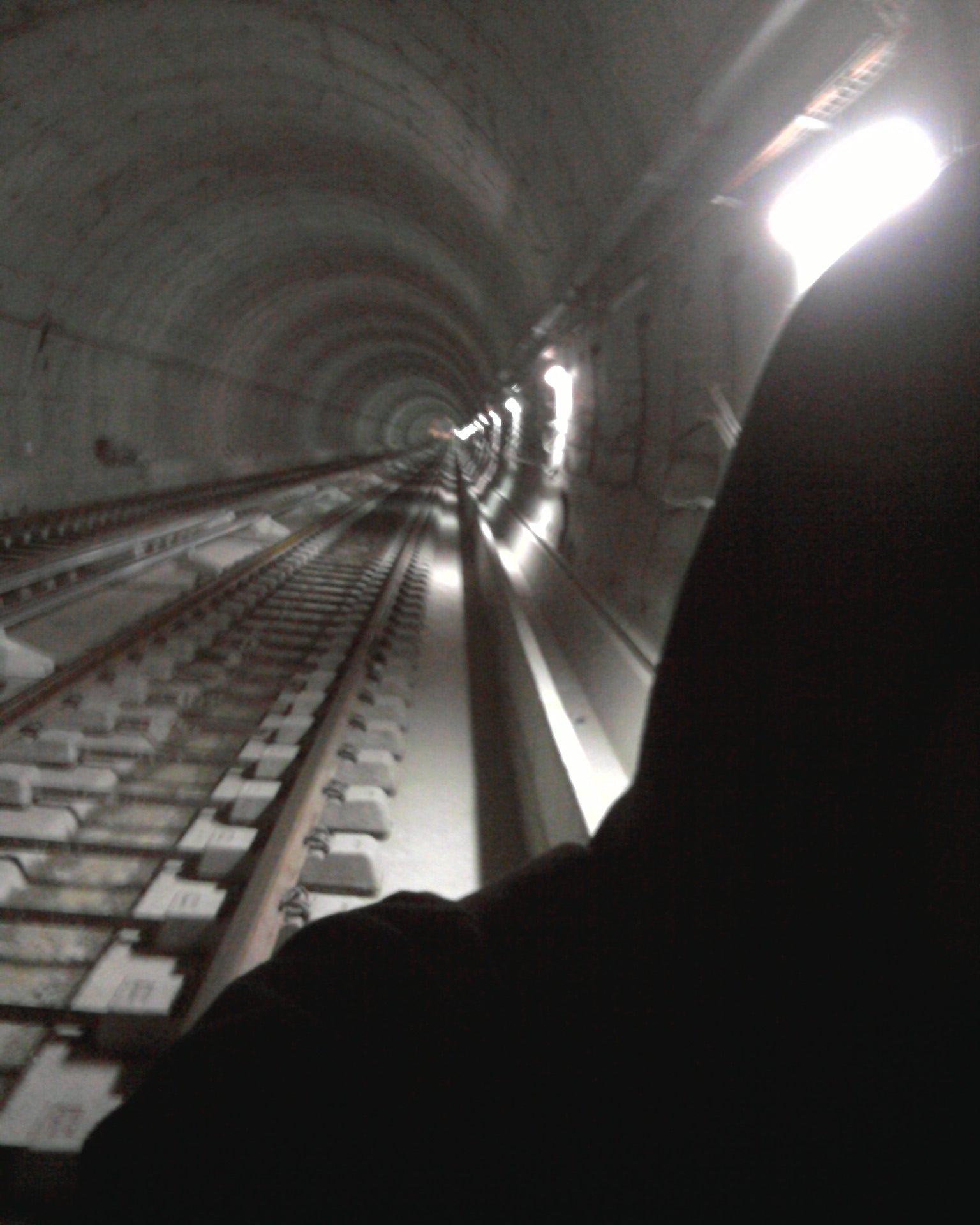 Spam in a tunnel with train tracks and a bright light at the end