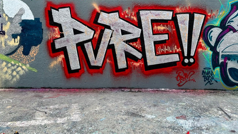Graffiti-covered wall with colorful street art on a building facade.